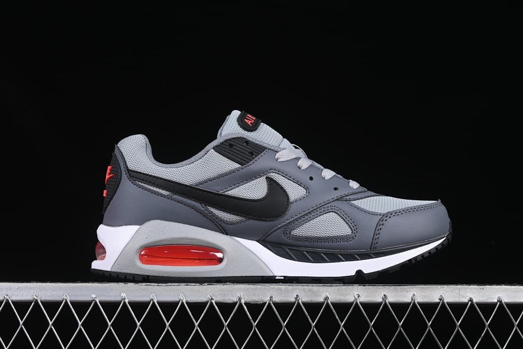 Side profile of the grey sneaker with black Swoosh and red heel unit