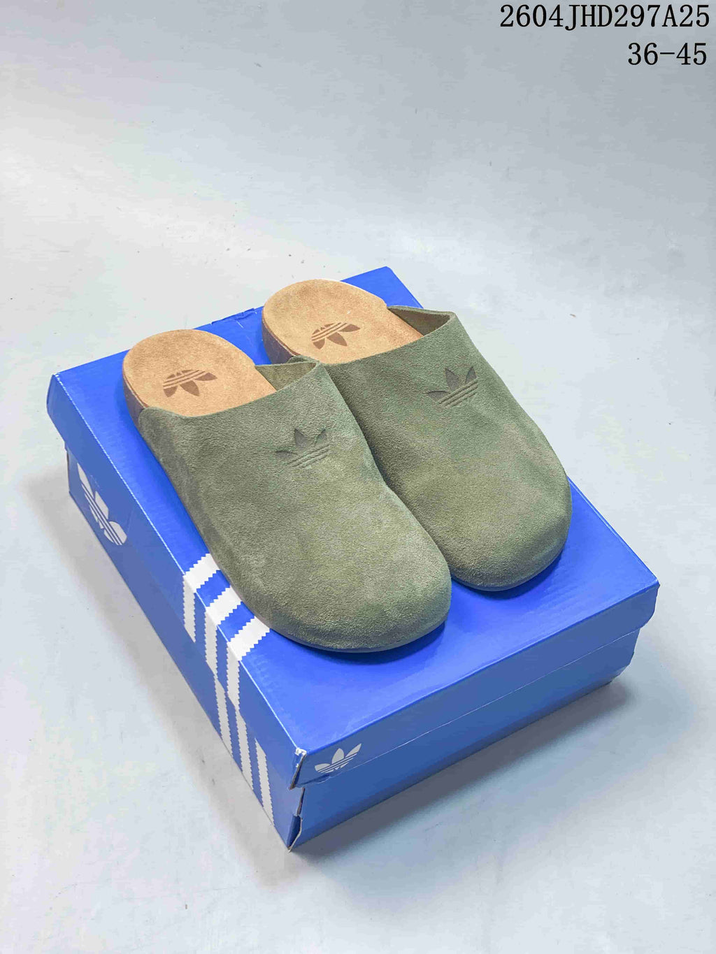 Olive green Adidas Originals Adimule closed-toe mule slippers on a blue box