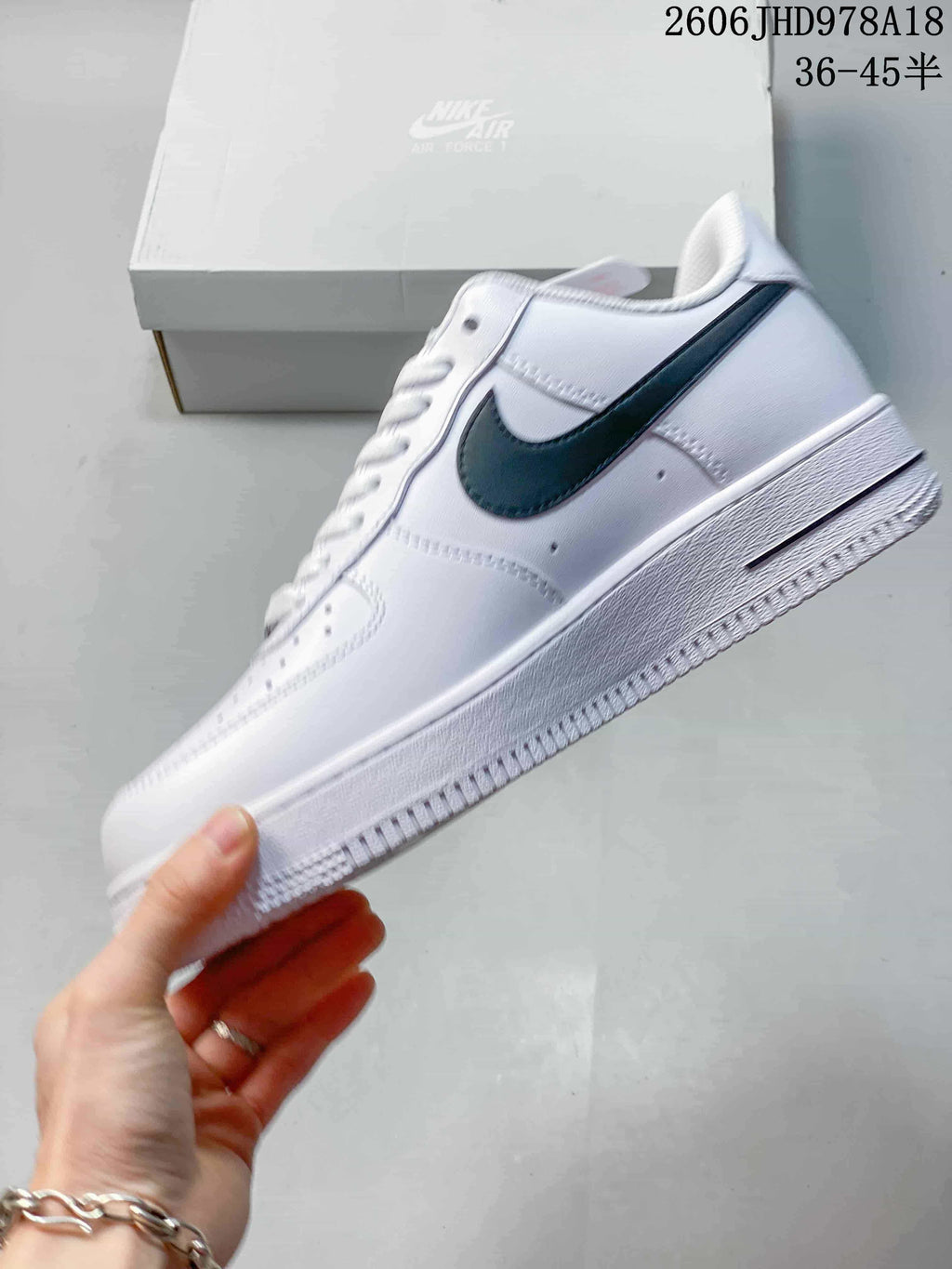 Side view of a white Nike Air Force 1 low-top sneaker with a black Swoosh
