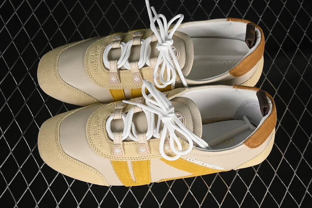 Top view of a pair of cream and yellow lace-up sneakers