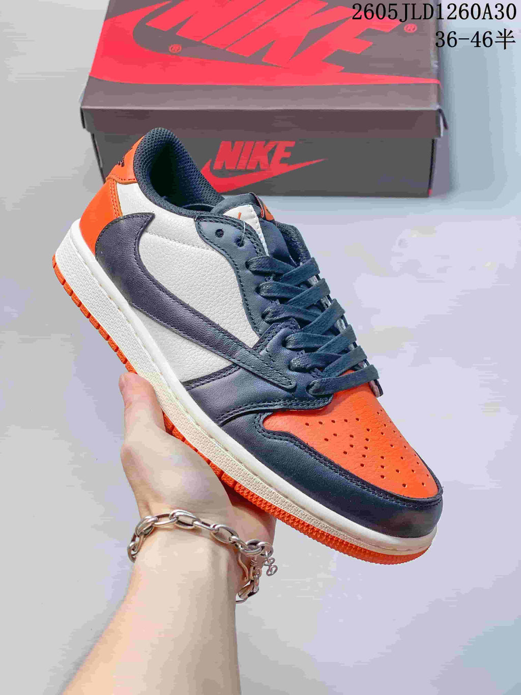 Angled side view of the orange, white, and charcoal Jordan Air Jordan 1 Low sneaker