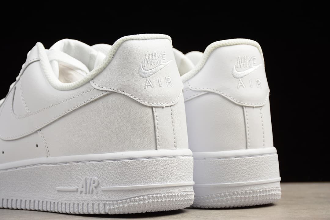 Rear and side view of the sneakers, with branding on the heel tabs.