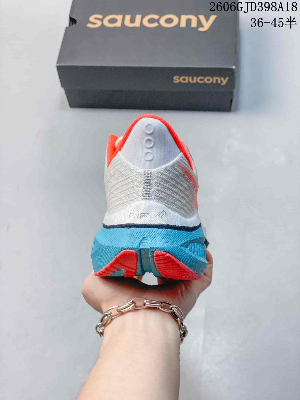 Rear view of the Saucony running shoe with coral collar trim and turquoise heel sole