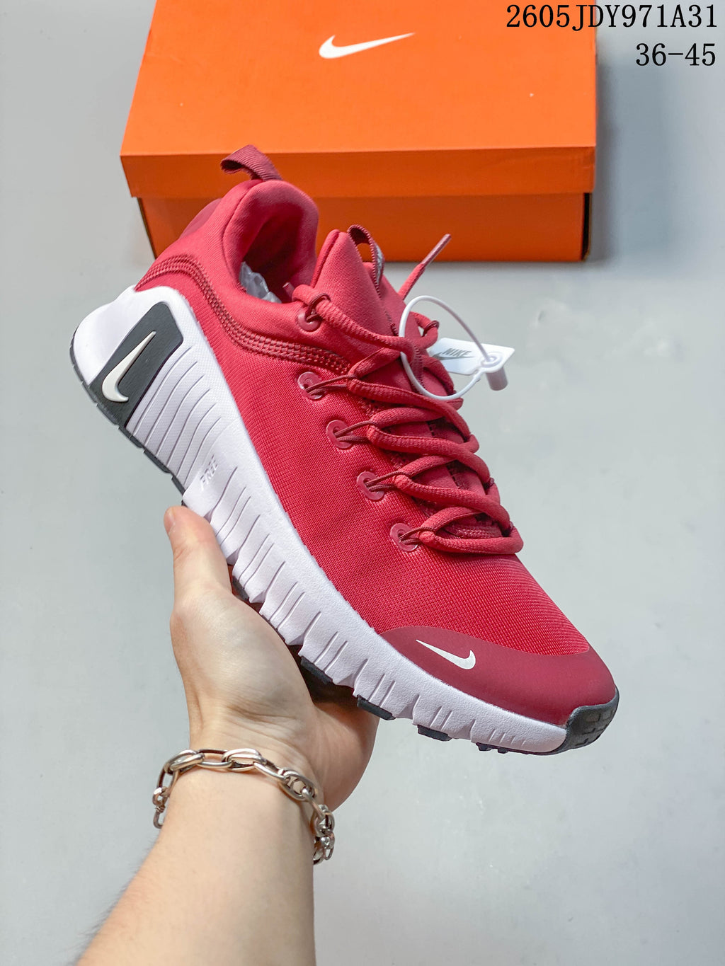 Angled side view of the red Nike Free Metcon 6 shoe with white sole and dark accents