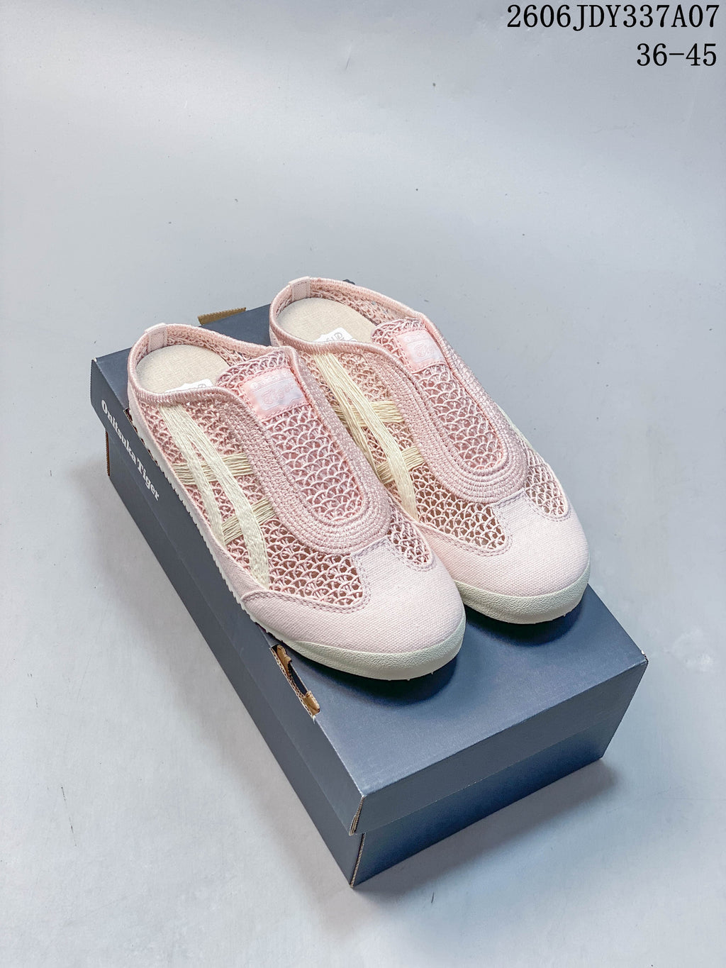 Pair of pink Onitsuka Tiger Mexico 66 Sabot slip-on shoes with cream stripes, shown on a shoe box