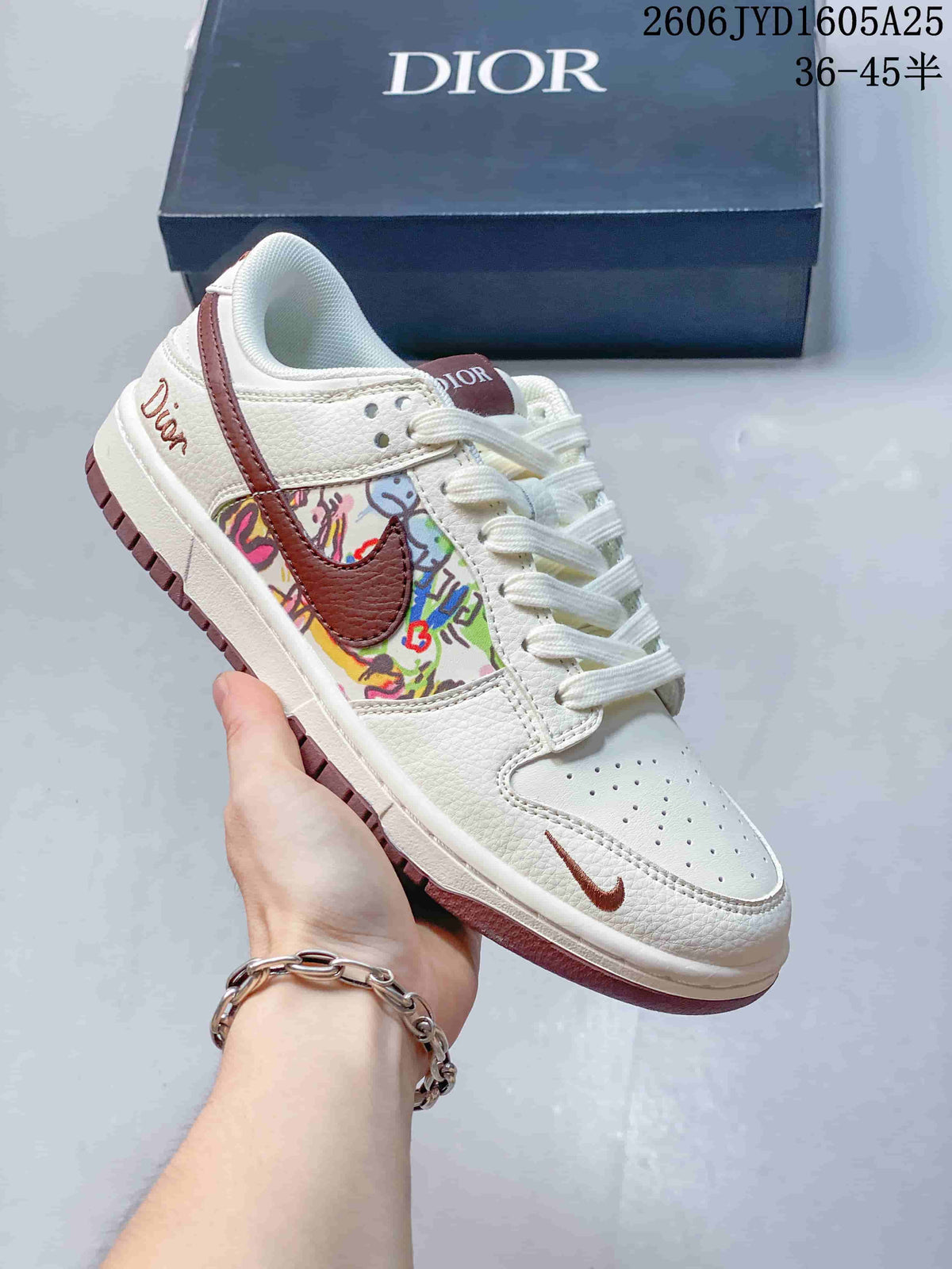 White low-top sneaker with brown accents and a colorful printed side panel, photographed with a dark box
