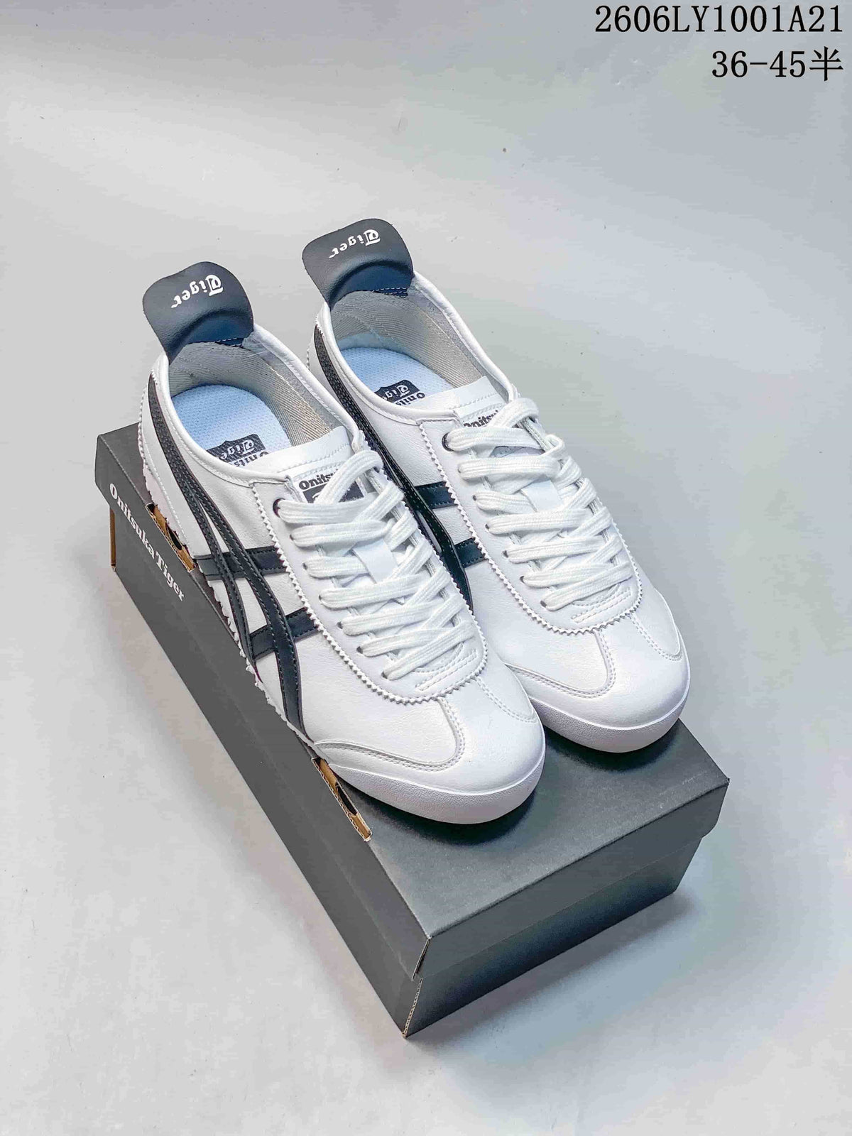 Pair of white Onitsuka Tiger Mexico 66 sneakers with dark navy stripes beside a shoebox