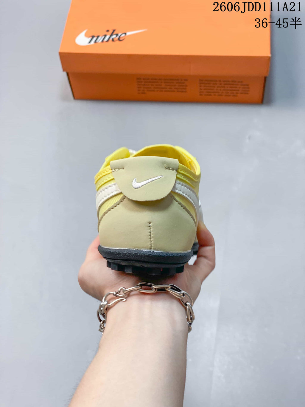 Rear view of the pale yellow sneaker showing its heel and outsole.