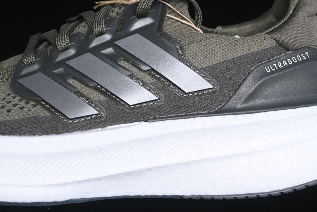 Close-up of the three-stripe side detail, olive upper, and white midsole