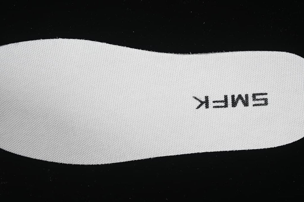 Close-up of a white insole with SMFK lettering