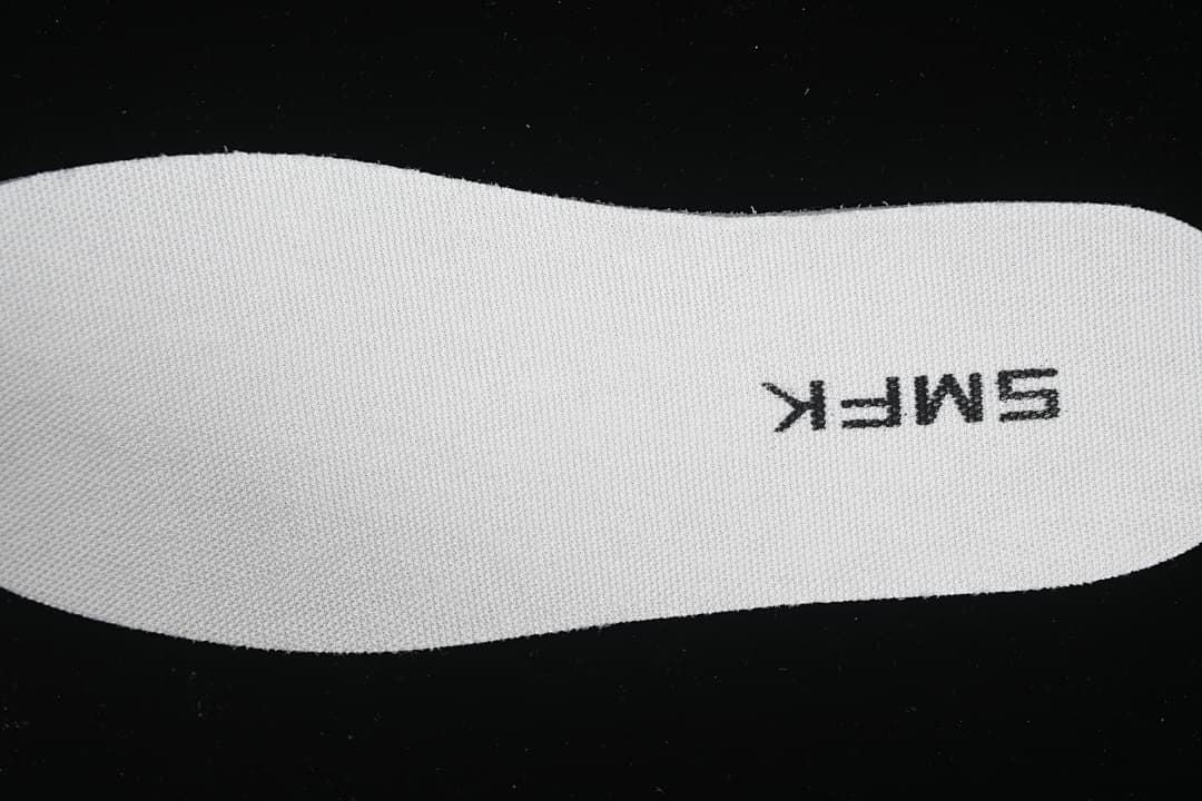 Close-up of a white insole with SMFK lettering