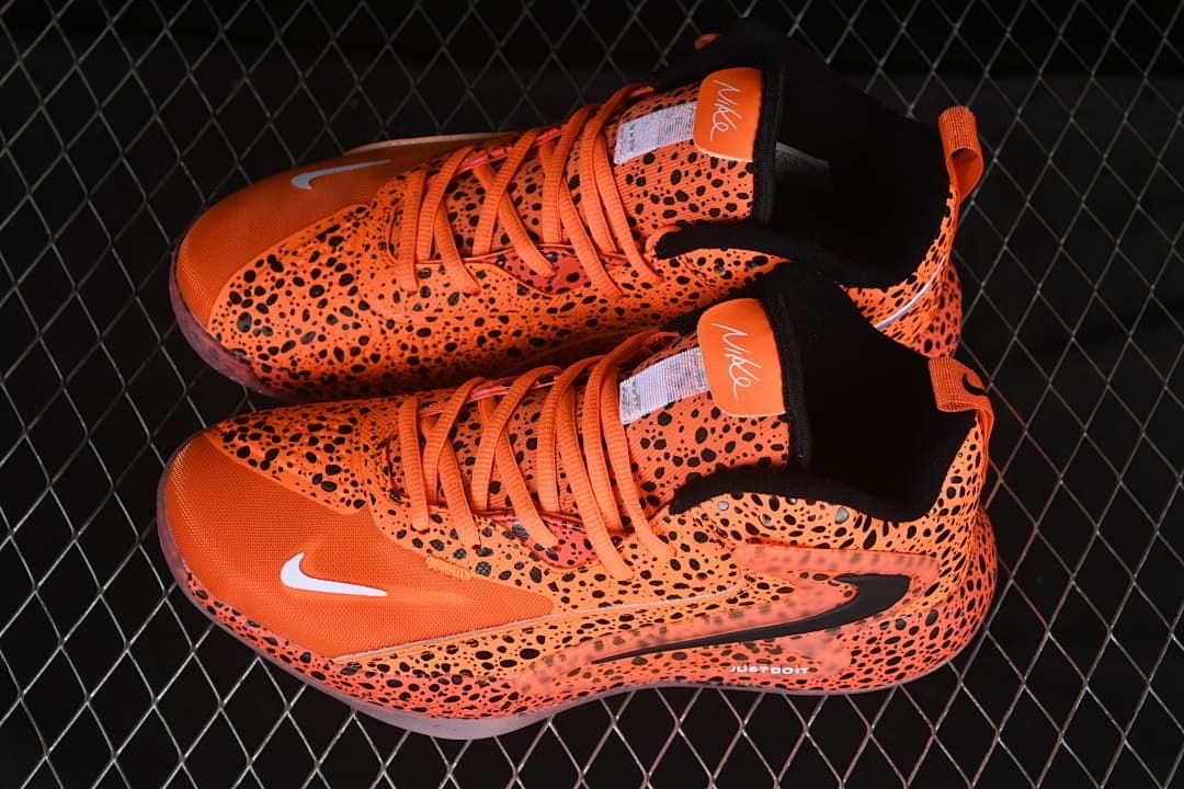 Pair of orange and black spotted Nike training shoes shown from above.