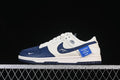 Side view of cream and navy Nike SB Dunk Low-style sneakers on a dark background