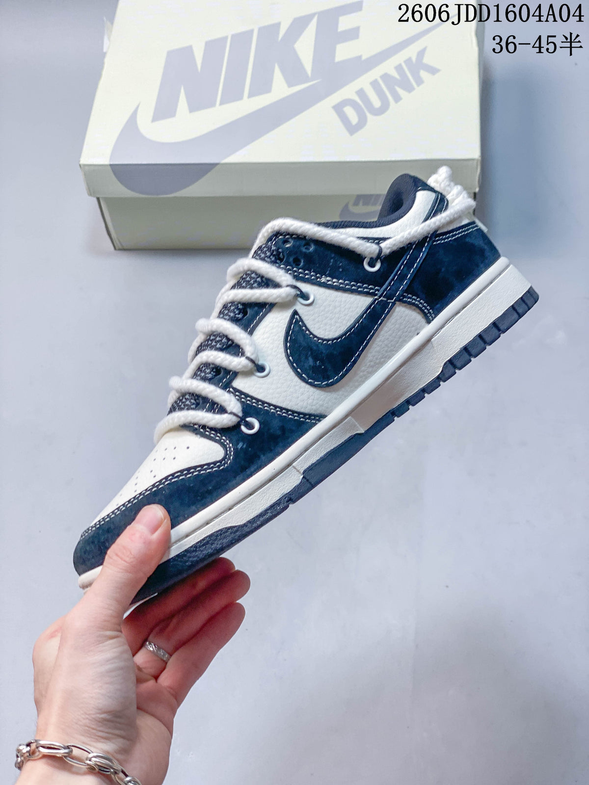 Side view of the white and navy low-top sneaker with contrasting overlays and white laces.