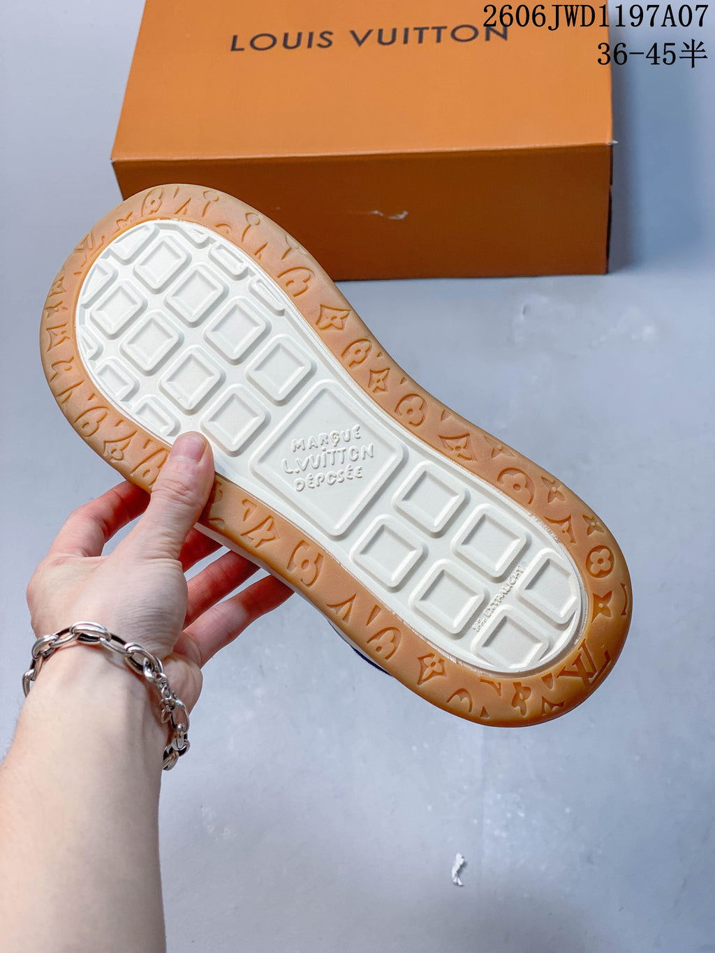 Underside of the sneaker showing a white tread center and gum-colored patterned outsole