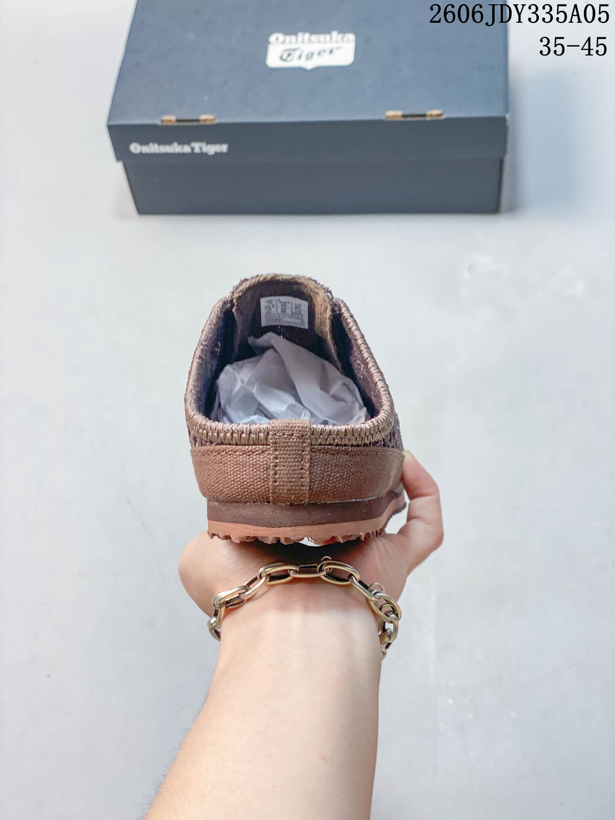 Rear view showing the open back of the brown slip-on shoe
