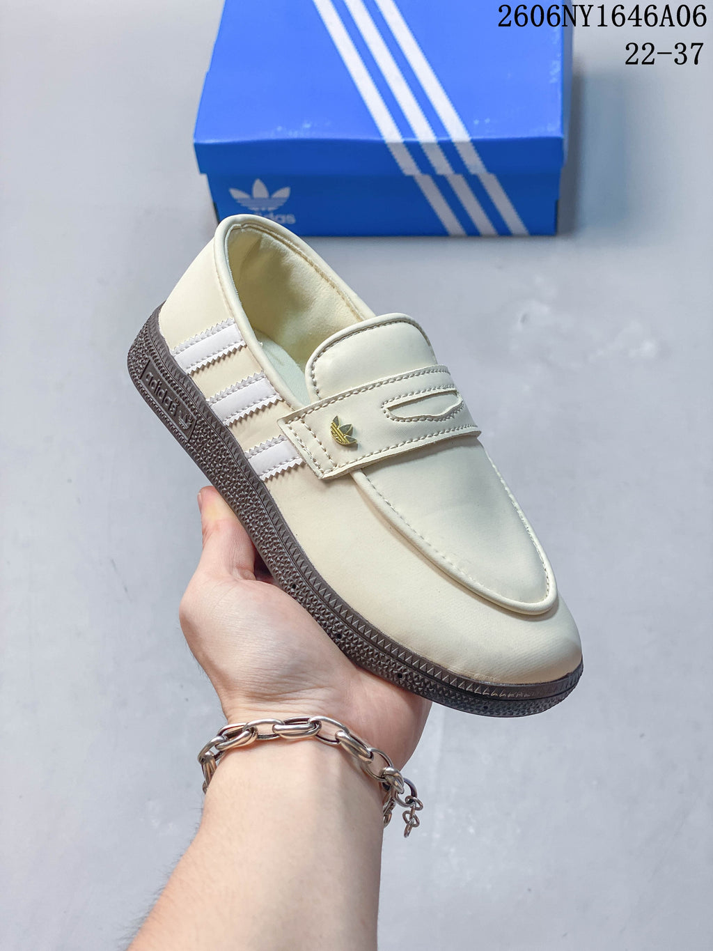 Angled view of the cream shoe with three stripes and keeper strap