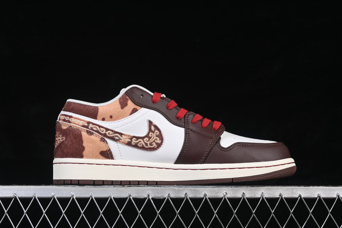 Side view of a white and dark brown Air Jordan 1 Low with red laces and patterned heel and Swoosh details.