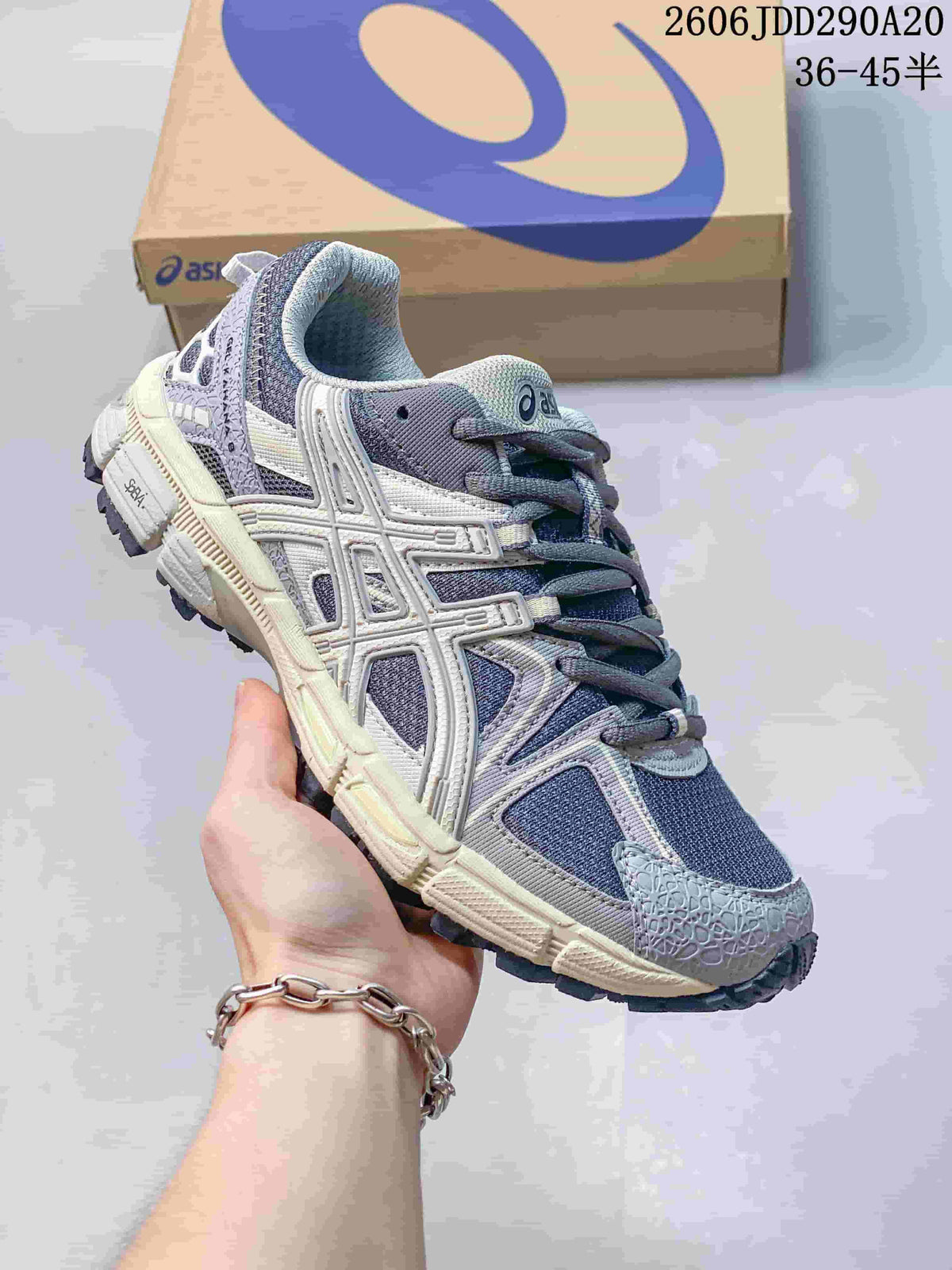 Close-up of a gray and navy ASICS Gel-Kahana 8 sneaker with cream-colored midsole details.