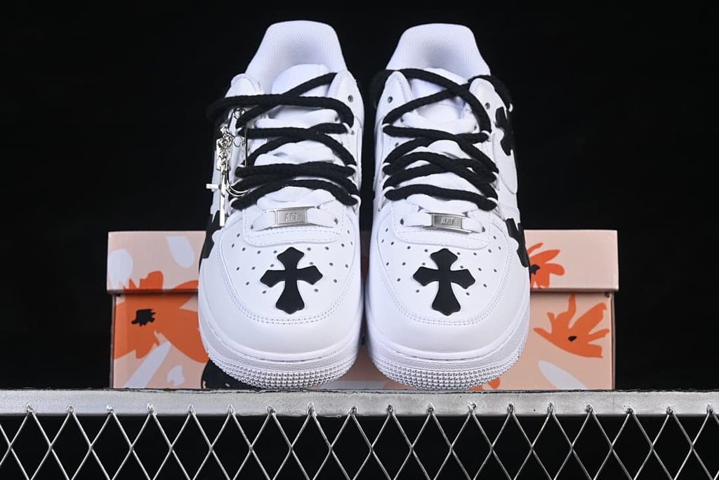 Front view of the pair, with black cross details on the toes and black laces.