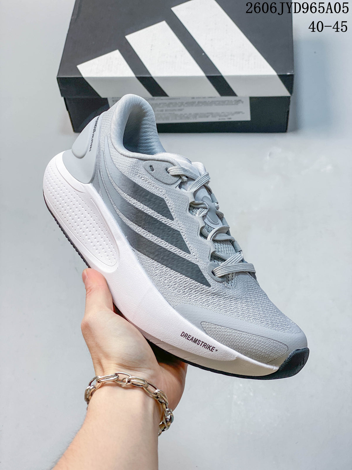 Close view of a light gray Adidas Cushionnova running shoe with dark stripes.