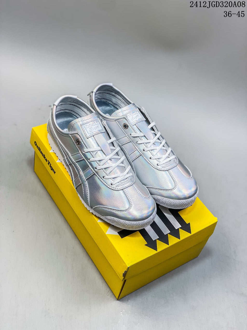 Pair of iridescent silver Onitsuka Tiger low-top sneakers displayed on a yellow shoebox
