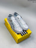 Pair of iridescent silver Onitsuka Tiger low-top sneakers displayed on a yellow shoebox