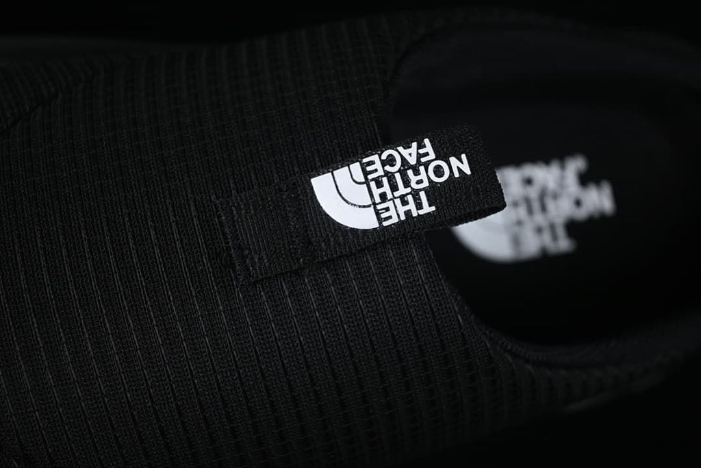 Close-up of the branded pull tab on the black upper