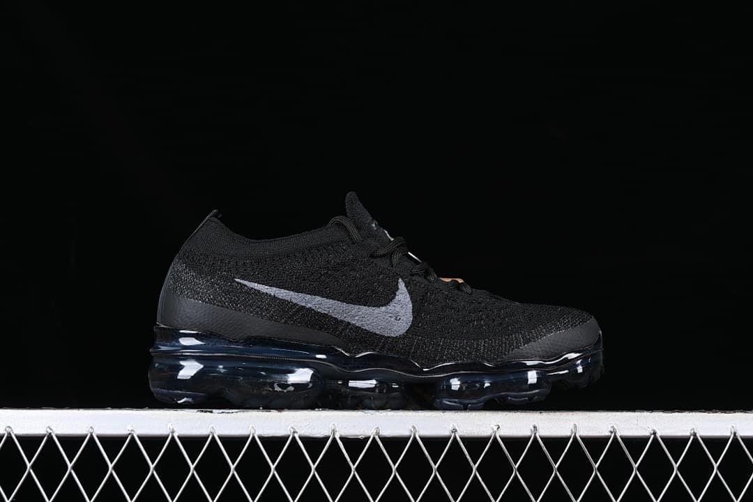 Side profile of the black sneaker with gray Swoosh and visible sole