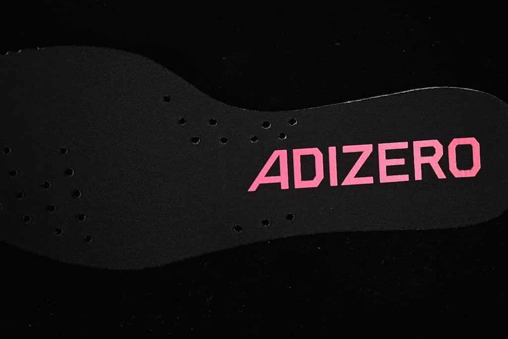 Black Adizero insole with pink lettering and perforations