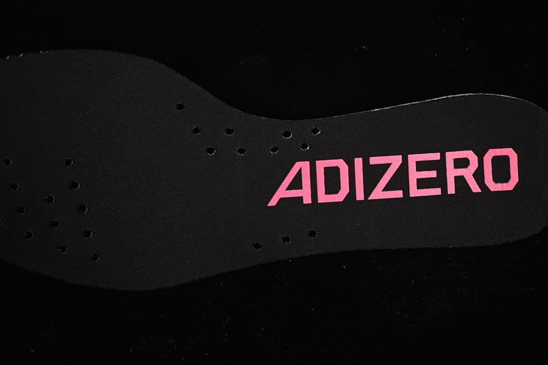 Black Adizero insole with pink lettering and perforations