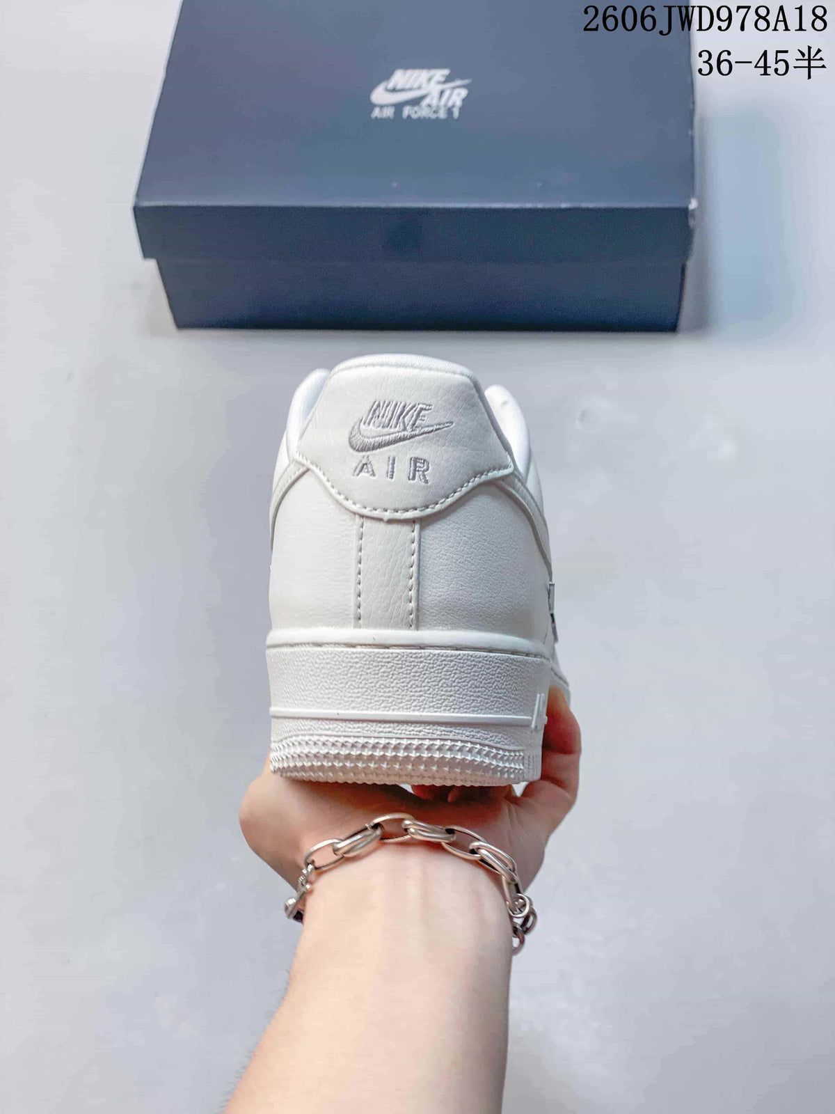 Rear view of the white sneaker showing the heel tab and outsole.