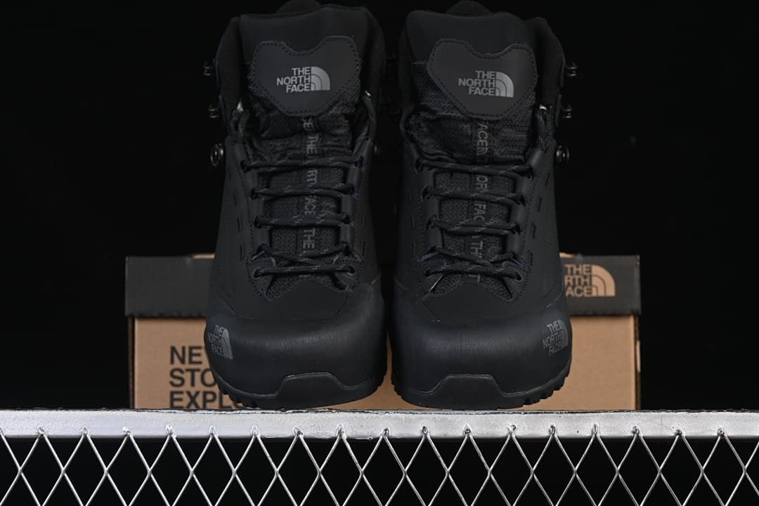 Front view of a pair of black lace-up mid boots.