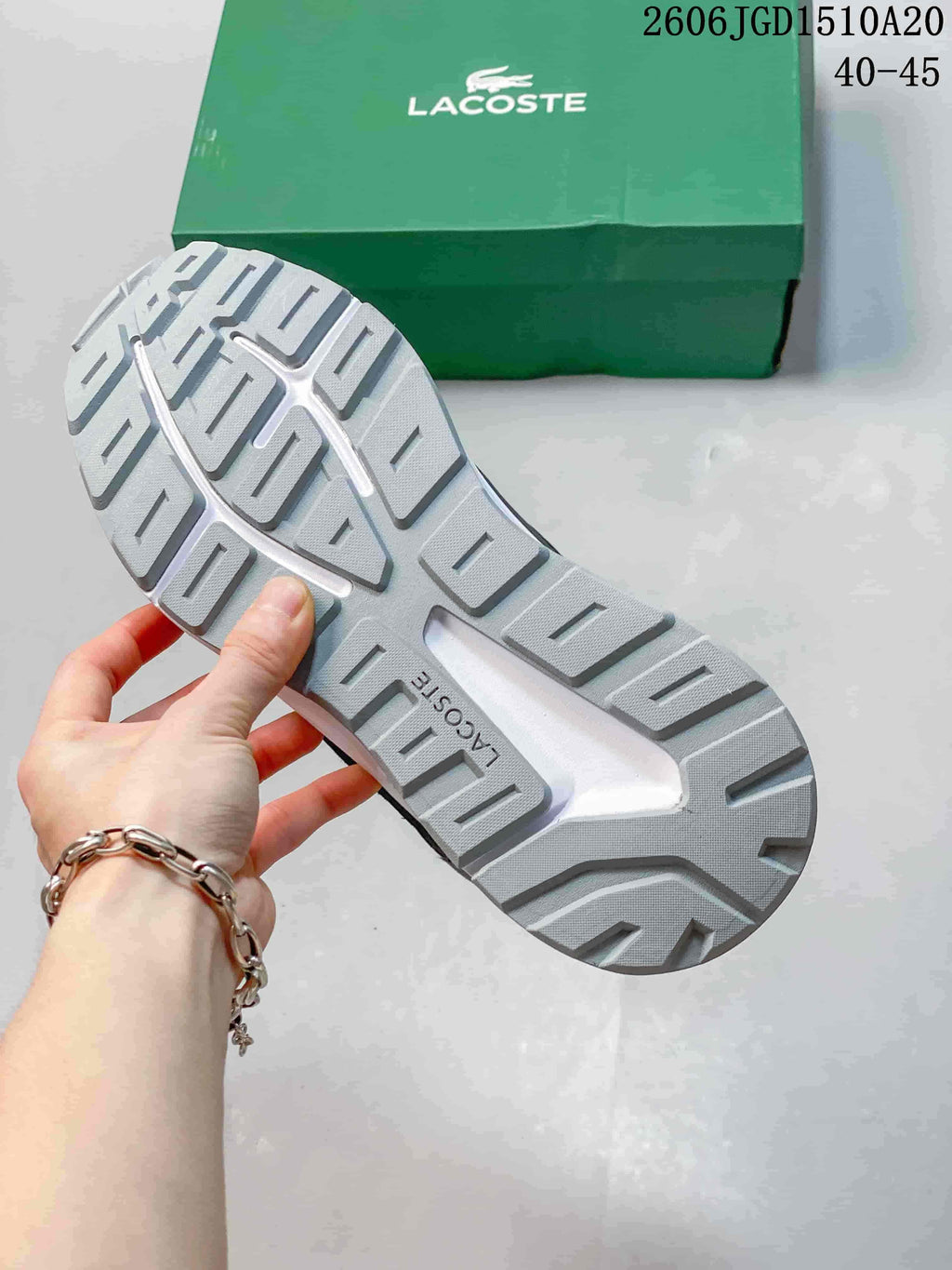 Close-up of the grey patterned outsole and Lacoste shoebox.