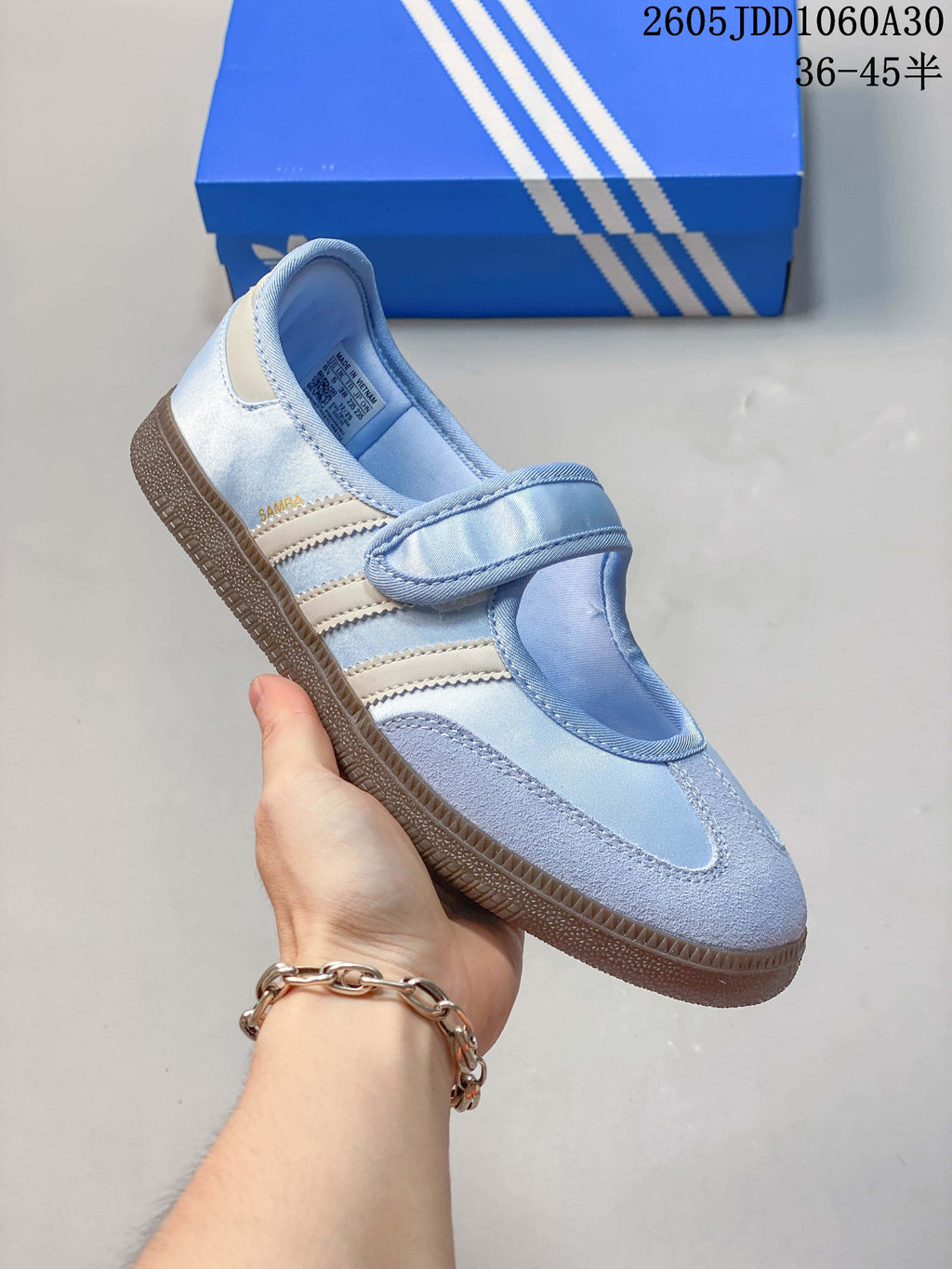Angled view of a pale blue sneaker with suede-like toe overlays and a hook-and-loop strap