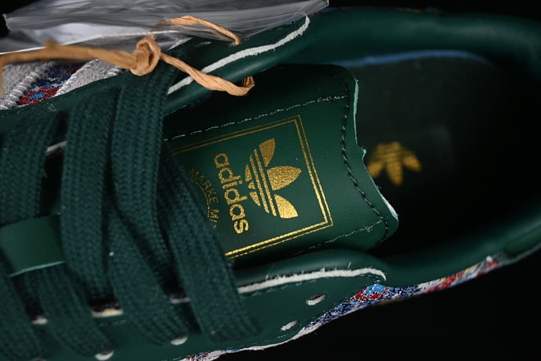 Close-up of the green tongue with gold adidas branding and dark green laces.