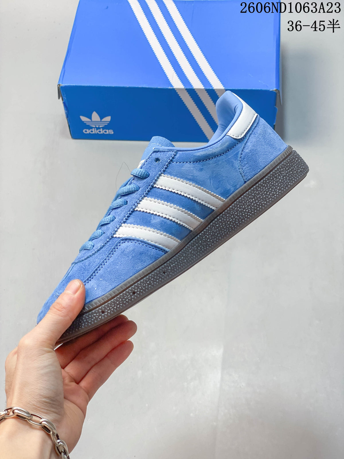 Side view of the blue low-top sneaker with white stripes and dark outsole