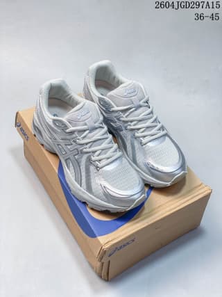 Pair of white and silver ASICS Gel-Flux CN sneakers displayed on top of the shoe box.
