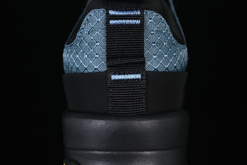 Rear view highlighting the heel pull tab and patterned blue panels.