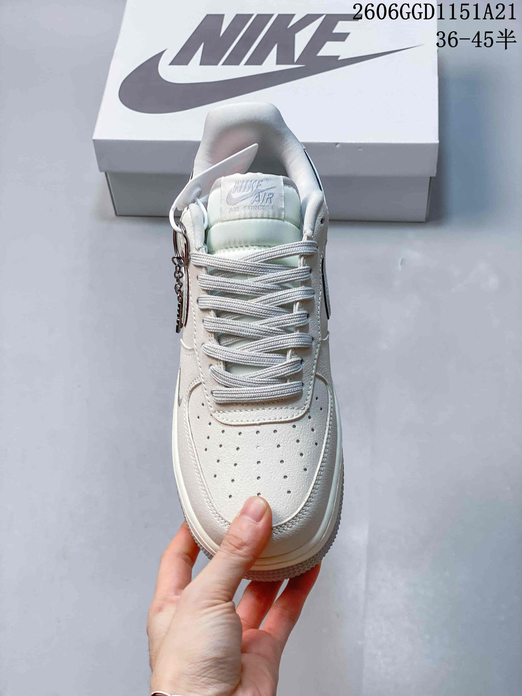 Front view of a cream Nike Air Force 1 Low with pale blue tongue details