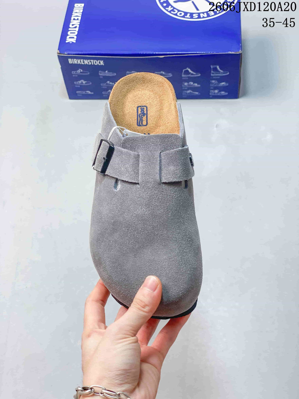 Front view of the gray clog showing its buckle strap and footbed
