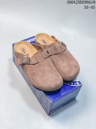 Pair of brown closed-toe clogs displayed on top of a branded shoe box.
