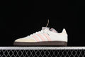Side view of off-white adidas Samba sneakers with pale pink stripes and a dark gum-style sole