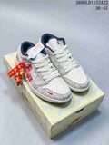Pair of white and grey Jordan Air Jordan 1 Low sneakers with navy accents and red graphics, shown on a patterned box.