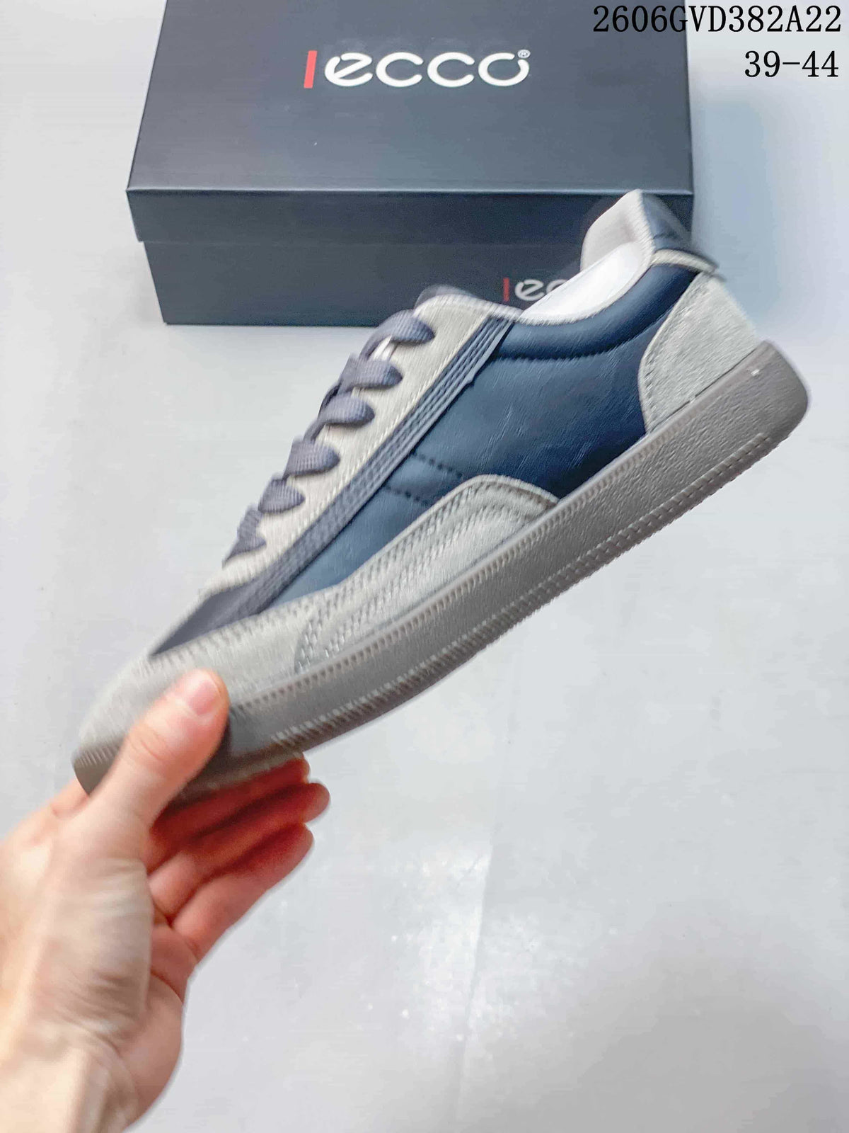 Side profile of the gray and navy lace-up sneaker.