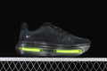 Side view of a black running shoe with a thick sole and bright volt-colored midsole accents.
