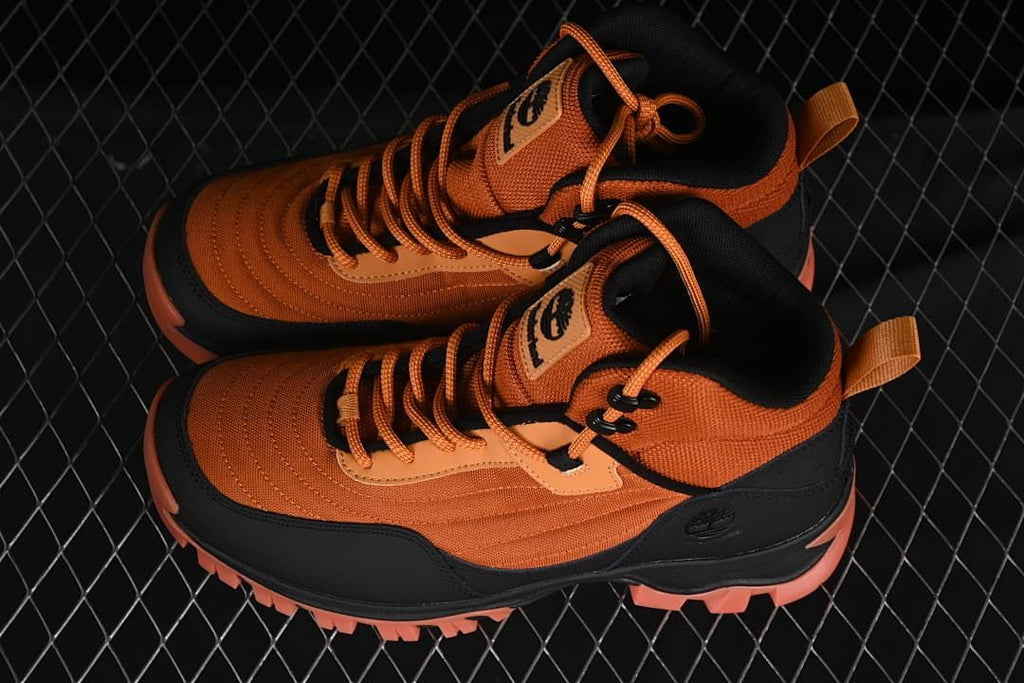Pair of orange and black mid hiking boots viewed from above