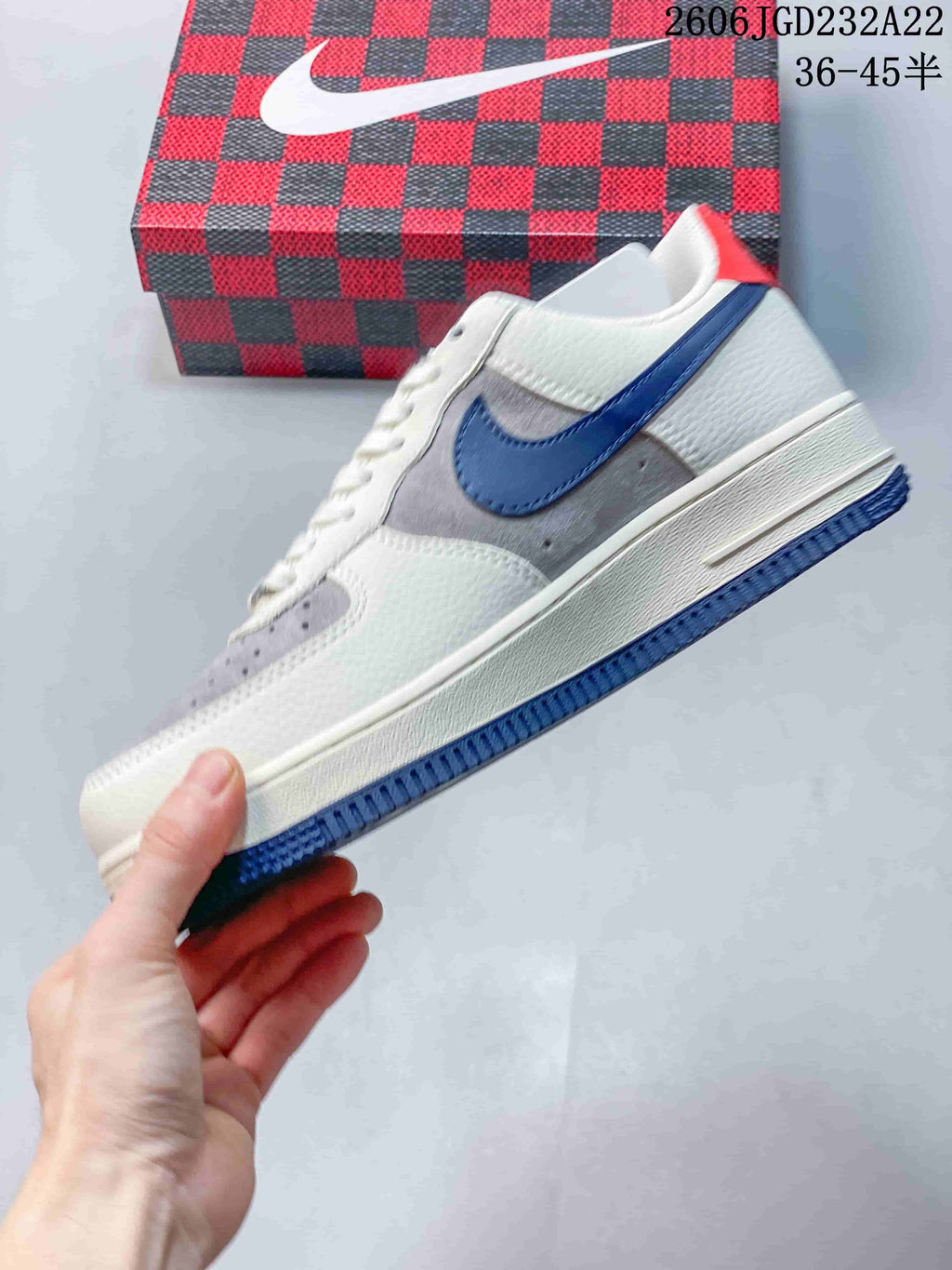 Side view of the low-top sneaker with grey panels, blue accents and white upper.