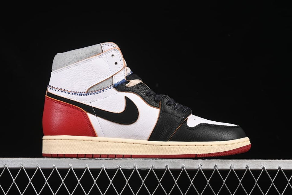 Side profile showing the black, white, and red upper with cream midsole