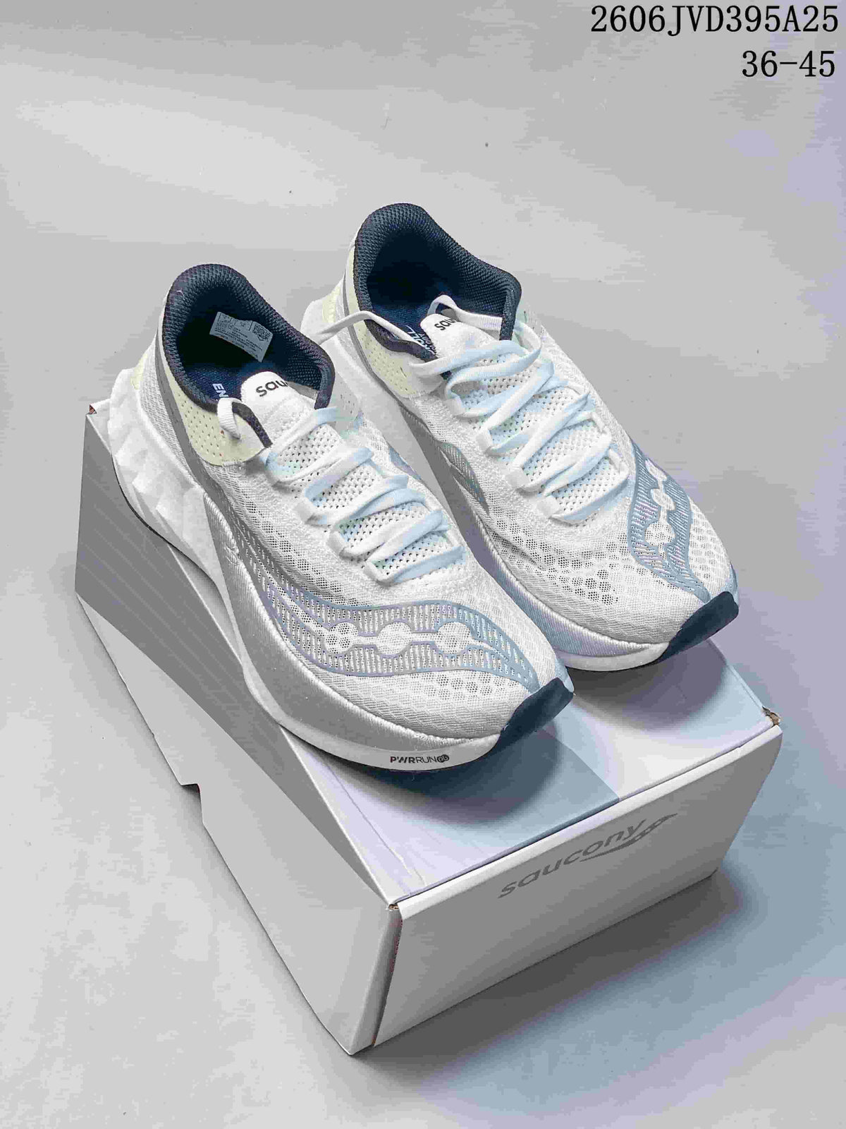 White Saucony Endorphin Speed 5 running shoes with blue-gray accents, displayed on a shoe box.